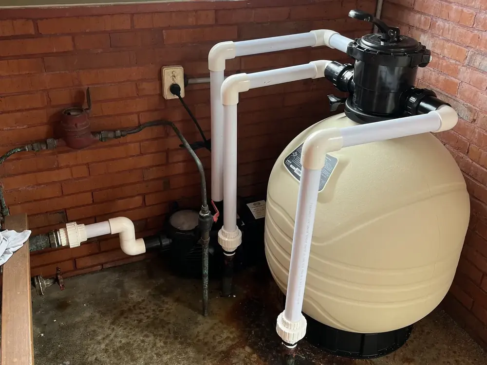 A newly installed pool sand filter and multiport valve, plumbed in white PVC