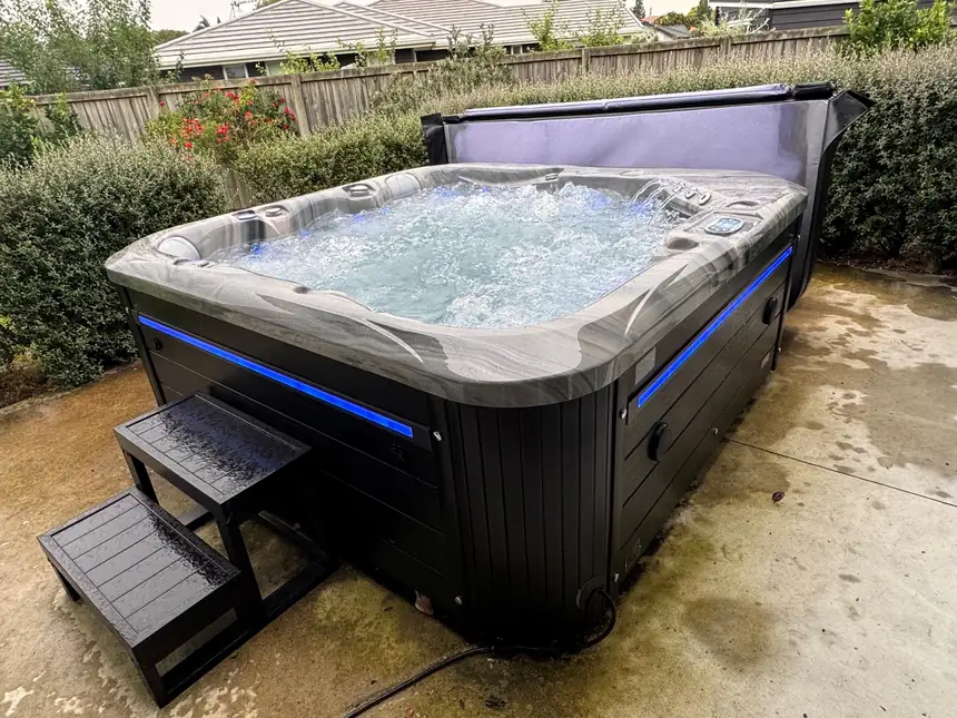 The same spa filled, running and lit, with the cover folded back